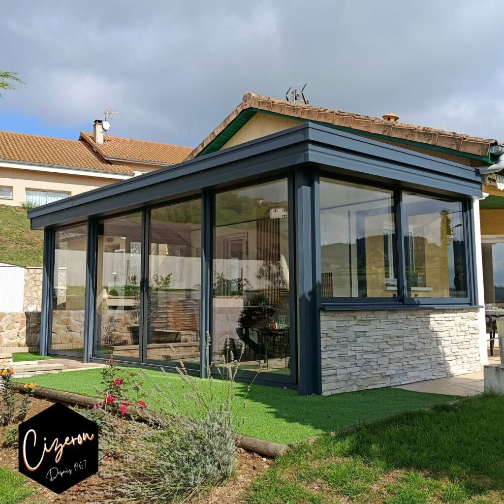 Véranda toiture plate, menuiseries fixe et coulissante, présence de soubassement, coloris gris